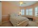 Cozy bedroom with plantation shutters and light colored walls and carpeting at 4821 Grand Banks Dr, Wimauma, FL 33598