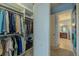 Walk-in closet adjacent to the primary bedroom features ample shelving, closet rods, and storage at 4821 Grand Banks Dr, Wimauma, FL 33598