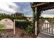 Community garden entrance with lush greenery, garden plots, and a charming gate at 4821 Grand Banks Dr, Wimauma, FL 33598