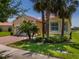 Charming home with colorful landscaping, mature trees, and red brick driveway at 4821 Grand Banks Dr, Wimauma, FL 33598