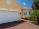 A home with a white garage door and brick driveway offers a clean and inviting exterior at 4821 Grand Banks Dr, Wimauma, FL 33598