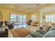 Spacious living room with tile floors, comfortable seating, and a view of the screened patio and lake at 4821 Grand Banks Dr, Wimauma, FL 33598