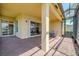 Covered outdoor patio with brick flooring and screened-in lanai, perfect for relaxing and entertaining at 4821 Grand Banks Dr, Wimauma, FL 33598
