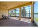 Covered patio featuring brick pavers, a ceiling fan, and scenic views of the lake at 4821 Grand Banks Dr, Wimauma, FL 33598