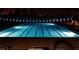 Night view of a pool illuminated with underwater lights and decorated with overhead pennants, providing a relaxing ambiance at 4821 Grand Banks Dr, Wimauma, FL 33598