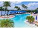 Large swimming pool with lounge chairs, tables, and shade canopies, near a waterway in a scenic outdoor setting at 4821 Grand Banks Dr, Wimauma, FL 33598