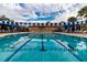 Full shot of a large outdoor pool with blue and white pennant decorations, showcasing the clear, inviting water at 4821 Grand Banks Dr, Wimauma, FL 33598
