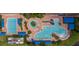 Overhead view of swimming pool complex, including a lap pool, leisure pool, and kiddie pool with plenty of lounge chairs at 4821 Grand Banks Dr, Wimauma, FL 33598