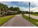Scenic walking path lined with palm trees and lush greenery in a residential neighborhood at 4821 Grand Banks Dr, Wimauma, FL 33598