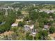 Overhead view of a secluded neighborhood with a home, pool, and long outbuilding amid mature trees and local roadways at 5305 Lenoir Ct, Plant City, FL 33566
