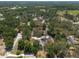 Aerial perspective of a house, pool, and outbuilding in a leafy neighborhood, with local buildings nearby at 5305 Lenoir Ct, Plant City, FL 33566