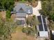 Aerial close-up of a home with a pool, solar panels and outbuilding surrounded by trees, showcasing privacy and amenities at 5305 Lenoir Ct, Plant City, FL 33566