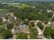 Wide aerial shot of a neighborhood with a house, pool, and outbuilding surrounded by verdant trees and foliage at 5305 Lenoir Ct, Plant City, FL 33566