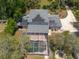 Aerial shot highlighting a home's solar panels, screened pool, and outbuilding, framed by surrounding trees at 5305 Lenoir Ct, Plant City, FL 33566