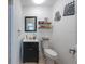 Charming powder room featuring elegant vanity, decorative mirror and car decor, complemented by a tiled floor at 5305 Lenoir Ct, Plant City, FL 33566