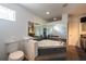 Bright bathroom featuring a corner bathtub with mirrored surround and a white toilet at 5305 Lenoir Ct, Plant City, FL 33566
