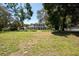 A well-manicured lawn with mature trees frames a charming two-story home, creating a welcoming scene at 5305 Lenoir Ct, Plant City, FL 33566