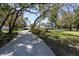 Charming two-story home features a beautifully landscaped yard with mature trees and a long driveway leading to a detached garage at 5305 Lenoir Ct, Plant City, FL 33566