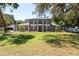 Stately two-story home with a lush green lawn, mature trees, and elegant architectural details at 5305 Lenoir Ct, Plant City, FL 33566