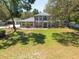 Two-story home with mature trees and lush lawn, exuding curb appeal and nestled in a serene setting at 5305 Lenoir Ct, Plant City, FL 33566