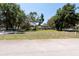 A picturesque two-story home is showcased behind a white fence and lush green lawn, framed by mature trees at 5305 Lenoir Ct, Plant City, FL 33566