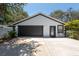 Detached garage with a modern black door, providing ample parking and storage space at 5305 Lenoir Ct, Plant City, FL 33566