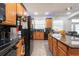 Bright kitchen features wood cabinetry, a breakfast bar with seating, and modern, black appliances at 5305 Lenoir Ct, Plant City, FL 33566