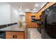 Bright kitchen features wood cabinetry, a breakfast bar with seating, and modern, black appliances at 5305 Lenoir Ct, Plant City, FL 33566