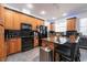 Bright kitchen features wood cabinetry, a breakfast bar with seating, and modern, black appliances at 5305 Lenoir Ct, Plant City, FL 33566