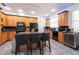 Bright kitchen features wood cabinetry, a breakfast bar with seating, and modern, black appliances at 5305 Lenoir Ct, Plant City, FL 33566