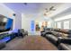 Open-concept living room with home theater seating, display shelves, and kitchen view at 5305 Lenoir Ct, Plant City, FL 33566
