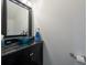 Stylish powder room featuring a unique blue glass vessel sink and dark vanity at 5305 Lenoir Ct, Plant City, FL 33566