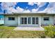 The backyard features a concrete patio, lush green grass, and the home's back facade at 5480 Orange Blossom N Rd, Pinellas Park, FL 33782