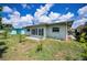 Exterior view of the backyard with a small patio, grass, and well-maintained landscaping around the property at 5480 Orange Blossom N Rd, Pinellas Park, FL 33782