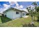 View of the backyard with a green lawn and patio area, perfect for outdoor relaxation at 5480 Orange Blossom N Rd, Pinellas Park, FL 33782