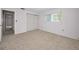 This empty bedroom has neutral carpet, a window with blinds, and a closet at 5480 Orange Blossom N Rd, Pinellas Park, FL 33782