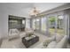 Bright sunroom features white sofa, neutral armchairs and a ceiling fan at 5480 Orange Blossom N Rd, Pinellas Park, FL 33782