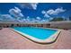 Community pool is surrounded by lush landscaping, and poolside seating at 5480 Orange Blossom N Rd, Pinellas Park, FL 33782