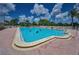 Community pool is surrounded by lush landscaping, and poolside seating at 5480 Orange Blossom N Rd, Pinellas Park, FL 33782