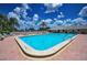 Community pool is surrounded by lush landscaping, and poolside seating at 5480 Orange Blossom N Rd, Pinellas Park, FL 33782