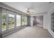Enclosed sunroom boasts natural light with a ceiling fan and access to the backyard and other rooms at 5480 Orange Blossom N Rd, Pinellas Park, FL 33782