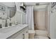 Well-lit bathroom featuring modern vanity, mirror, bathtub with shower, and a decorative shelf at 550 George S St, Tarpon Springs, FL 34688