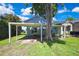 Charming home with a convenient carport, lush green lawn, and mature trees adding to curb appeal at 550 George S St, Tarpon Springs, FL 34688