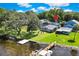 Lakeside home featuring a private dock and lush landscaping at 550 George S St, Tarpon Springs, FL 34688