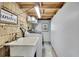 Functional laundry room features wood paneling, utility sink, and a modern washing machine at 550 George S St, Tarpon Springs, FL 34688
