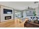 Bright living room with fireplace, wood floors, and doors to the sunroom with views of the water at 550 George S St, Tarpon Springs, FL 34688