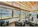Relaxing sunroom with wood ceiling features large windows with water and backyard views and comfortable seating at 550 George S St, Tarpon Springs, FL 34688