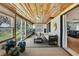 Cozy sunroom with wood plank ceiling, water views, comfortable seating and access to backyard at 550 George S St, Tarpon Springs, FL 34688
