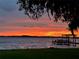 Picturesque waterfront view at sunset with a dock, framed by lush trees and tranquil water at 550 George S St, Tarpon Springs, FL 34688