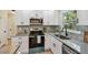 Stylish kitchen showcasing white cabinets, stainless steel appliances, granite countertops and designer tile backsplash at 5624 62Nd N St, St Petersburg, FL 33709